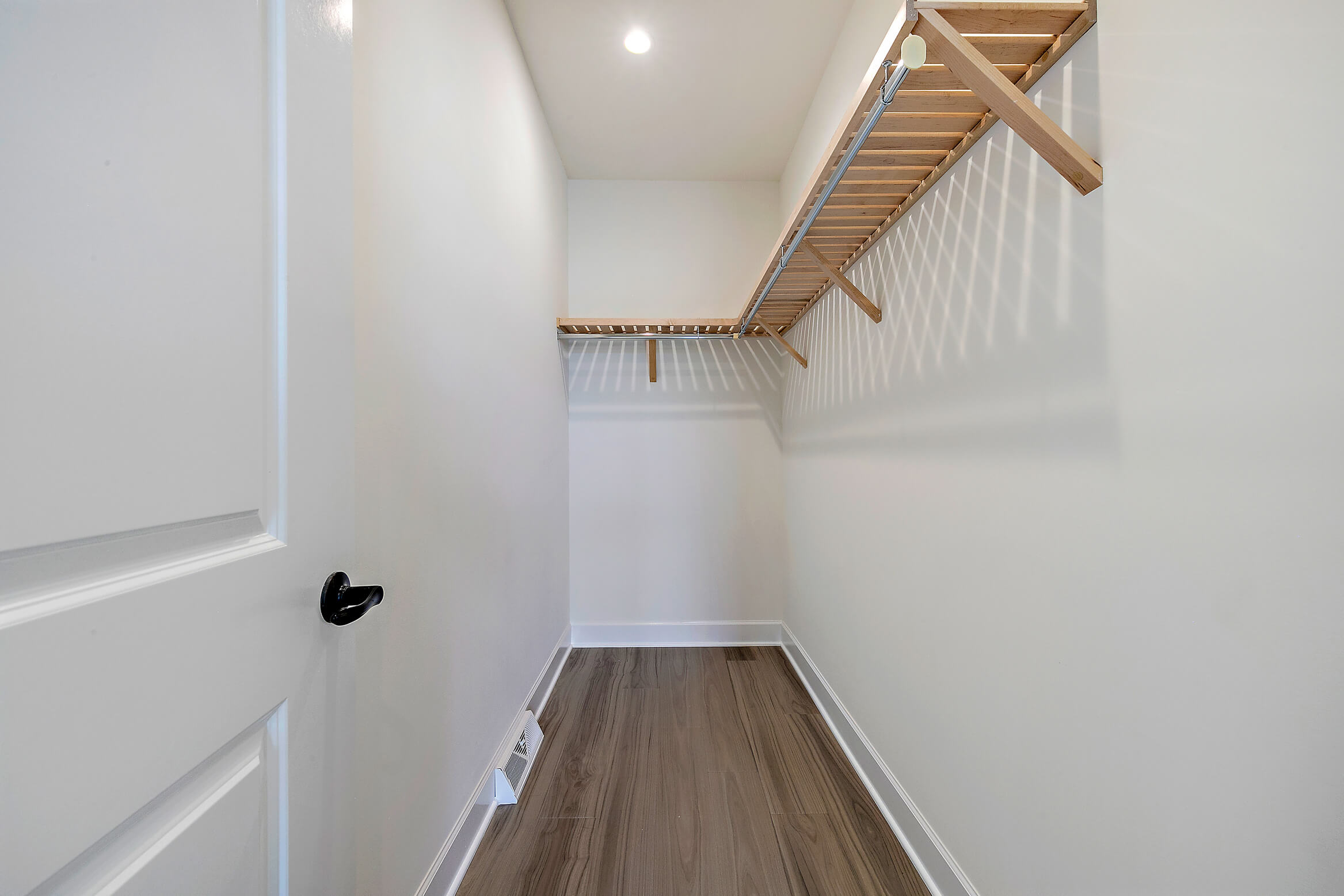 Walk in closet with wooden shelves